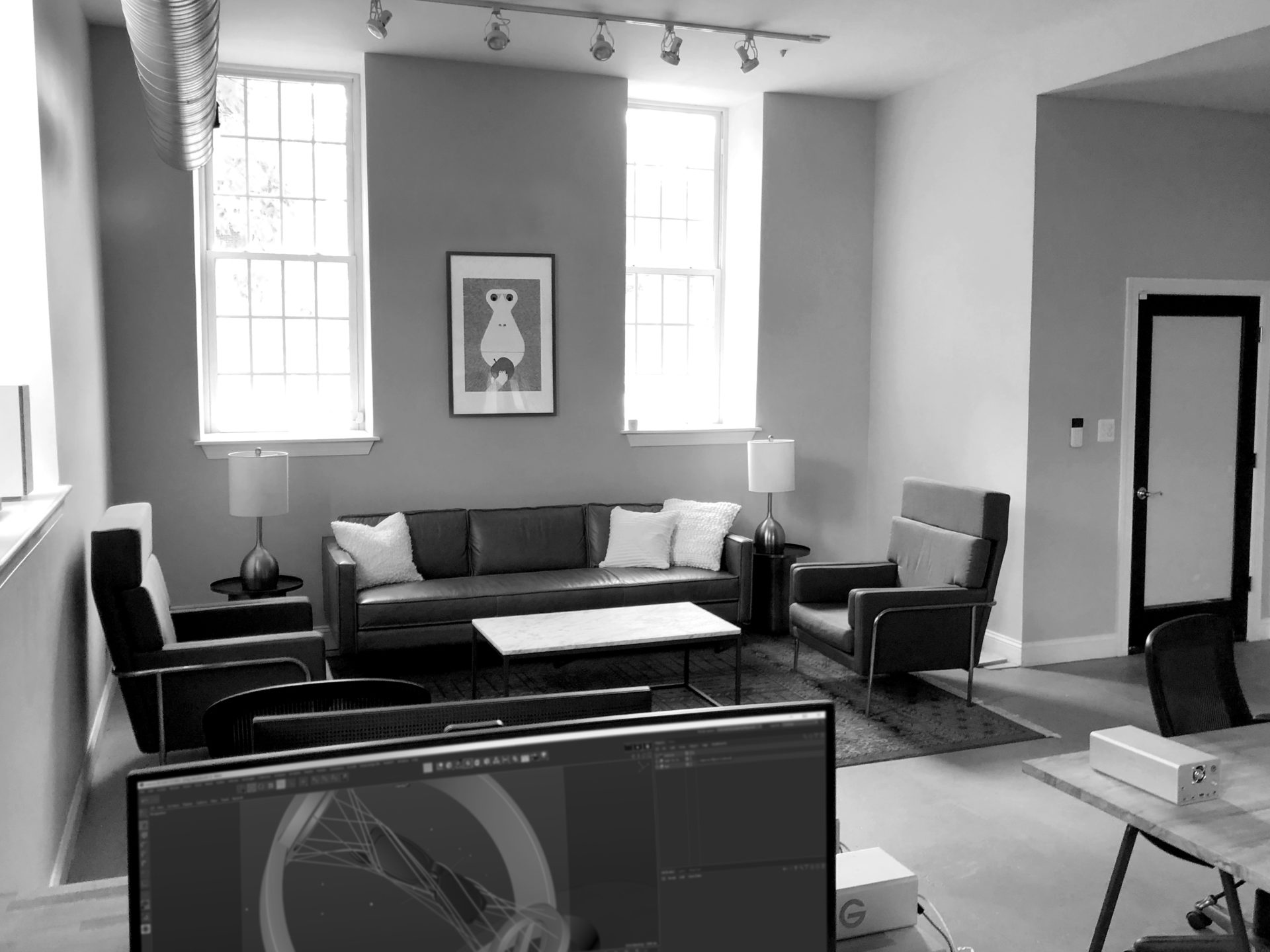 Wide shot of a sitting area with computer screens in the foreground